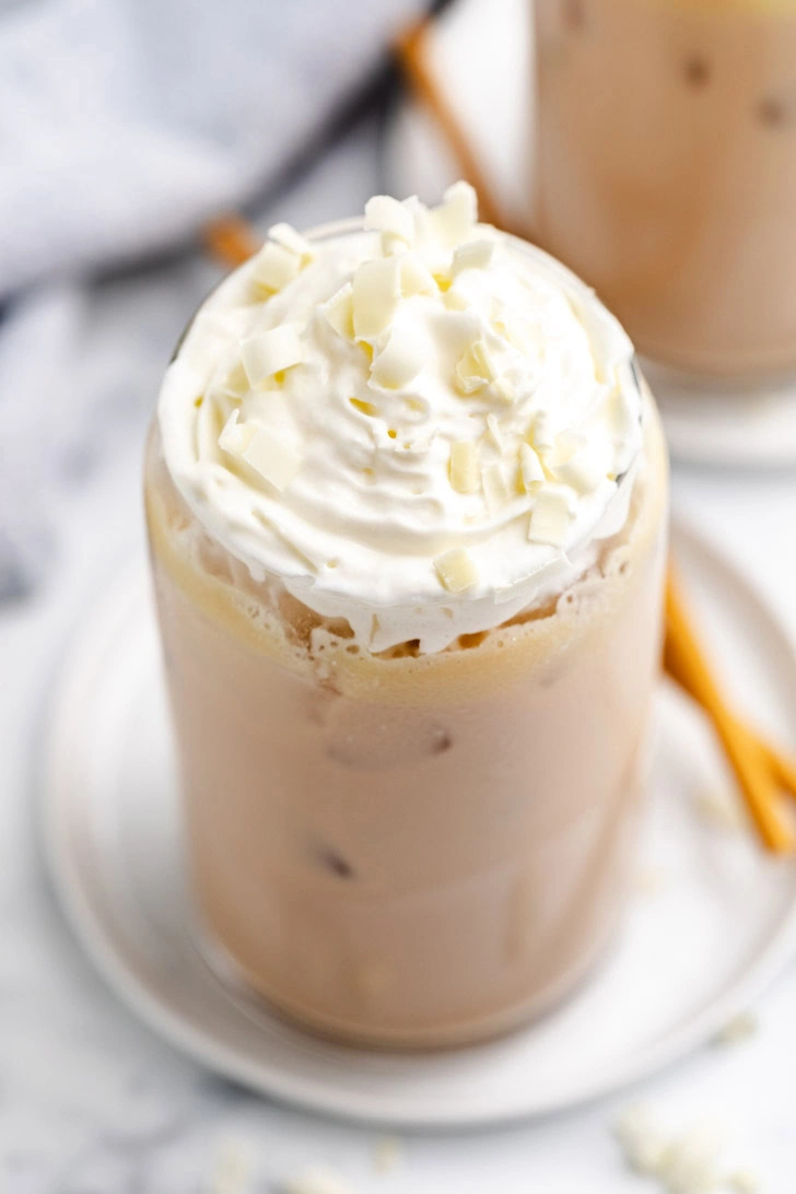 Tall glass filled with an iced coffee drink.