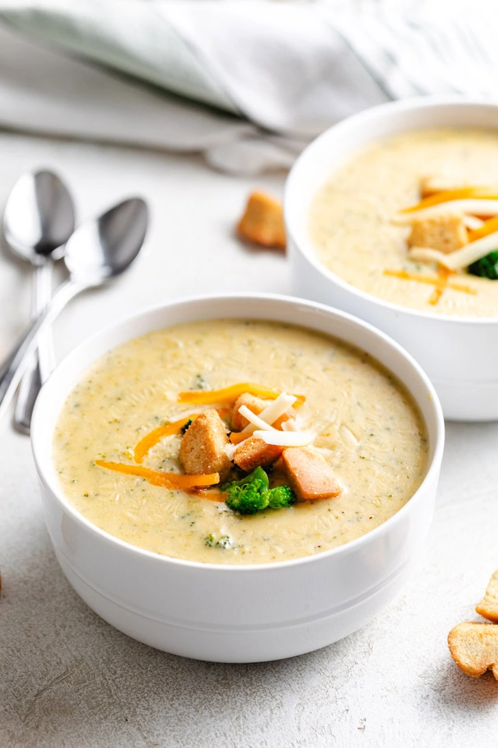 Cheese and croutons on a bowl of broccoli and cheese soup.