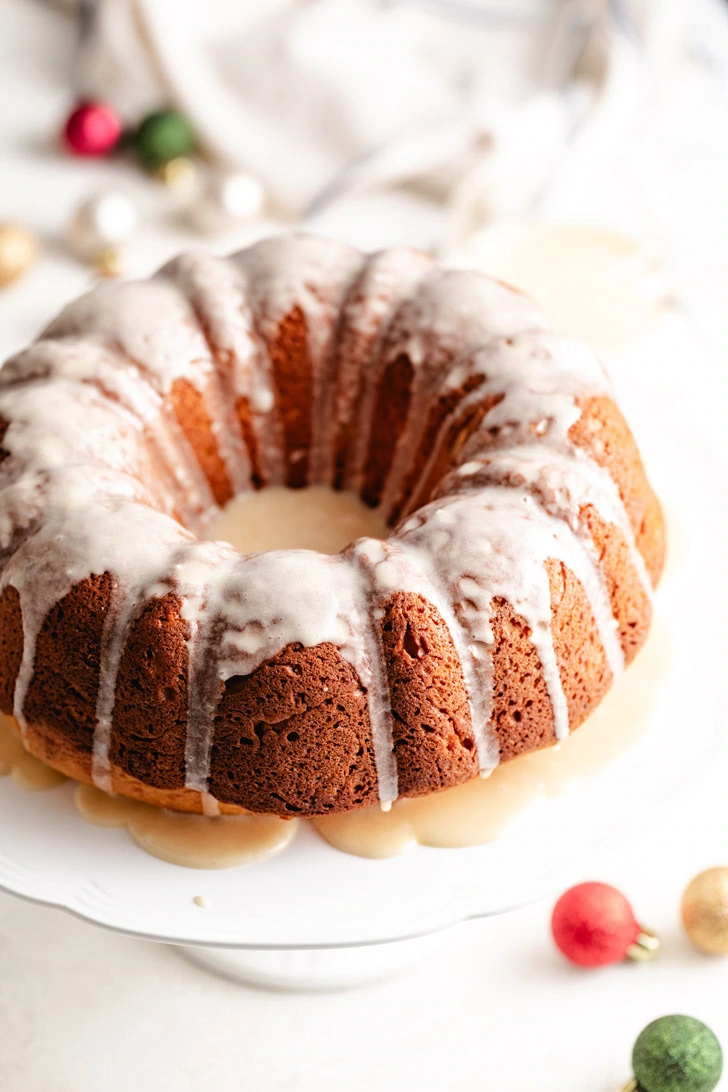 Eggnog bundt cake with glaze on a cake stand.