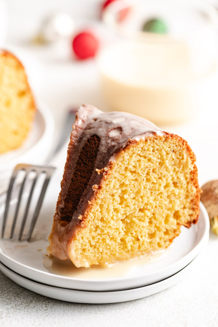 Fluffy eggnog bundt cake on a stack of white plates.