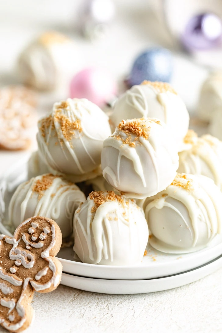 Vanilla dipped gingerbread truffles on a stack of plates.