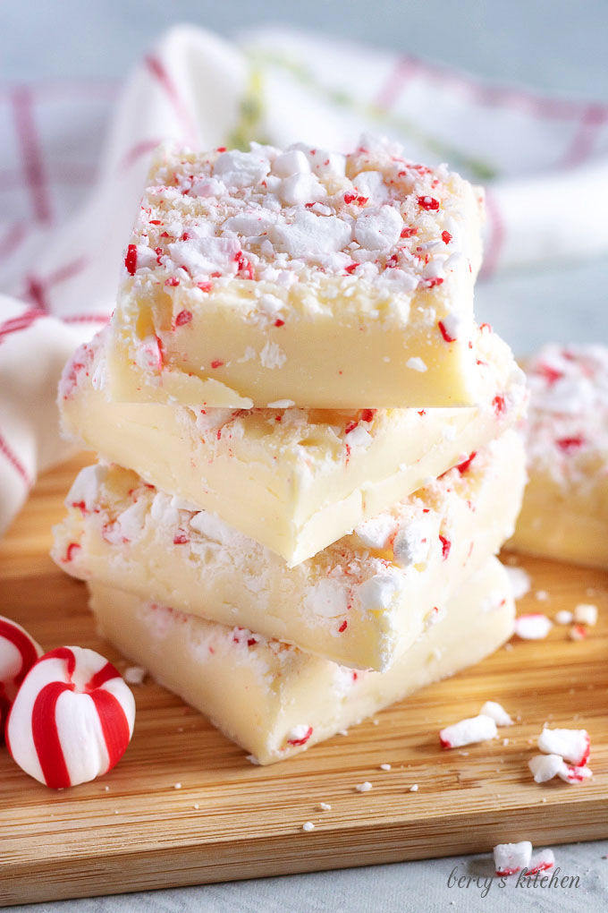 Stack of peppermint fudge on a wooden board.