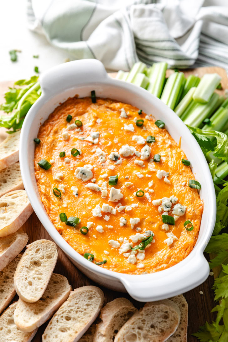 Baguette and celery next to a bowl of dip.