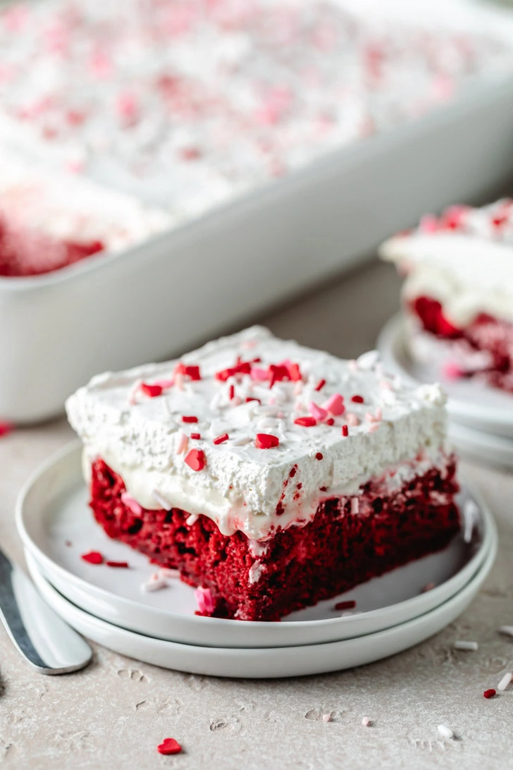 Valentine's sprinkles on a slice of red velvet poke cake.