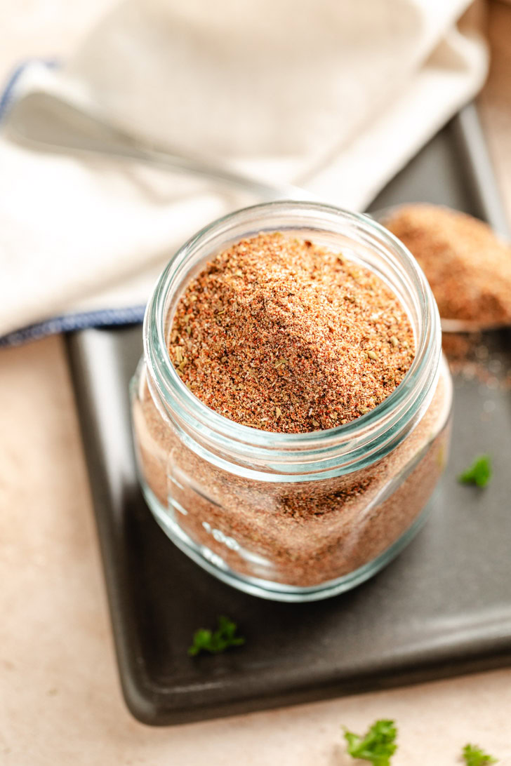 A glass jar of spice blend for making chili.