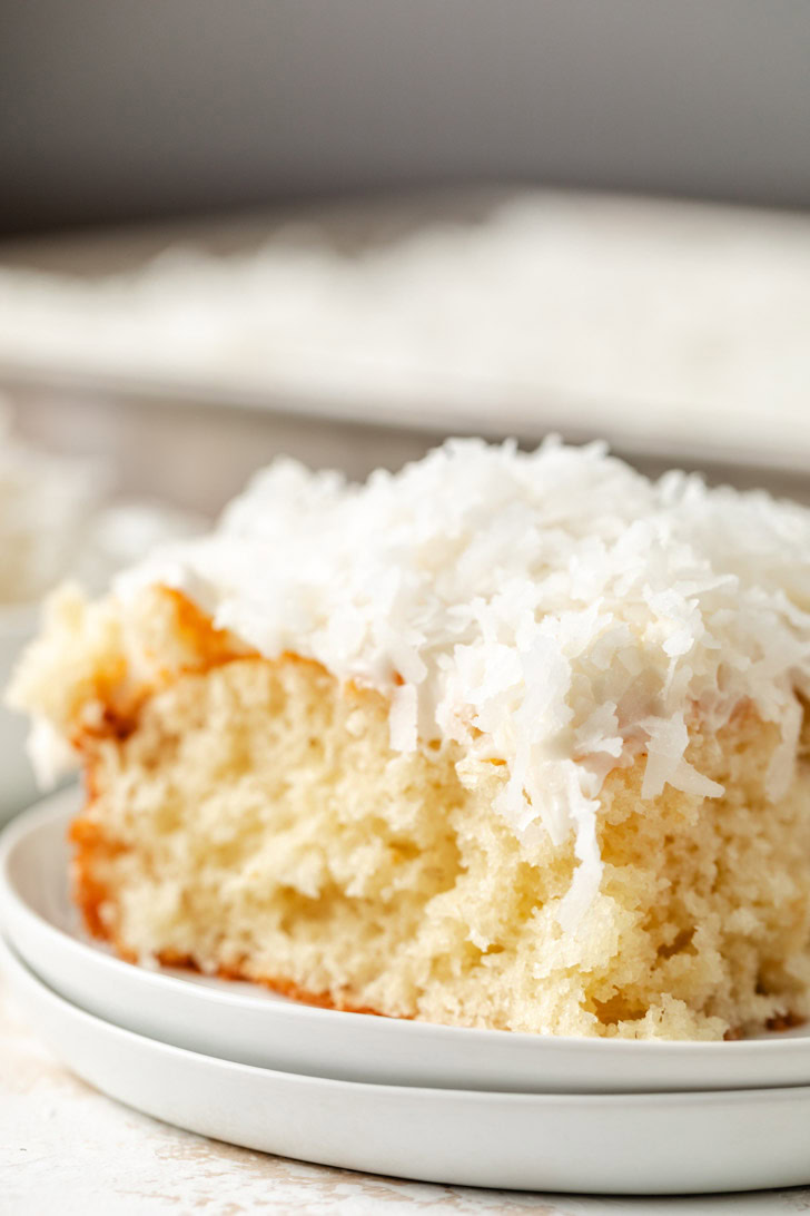 A light and airy coconut cake with cream cheese frosting and sweetened coconut flakes.