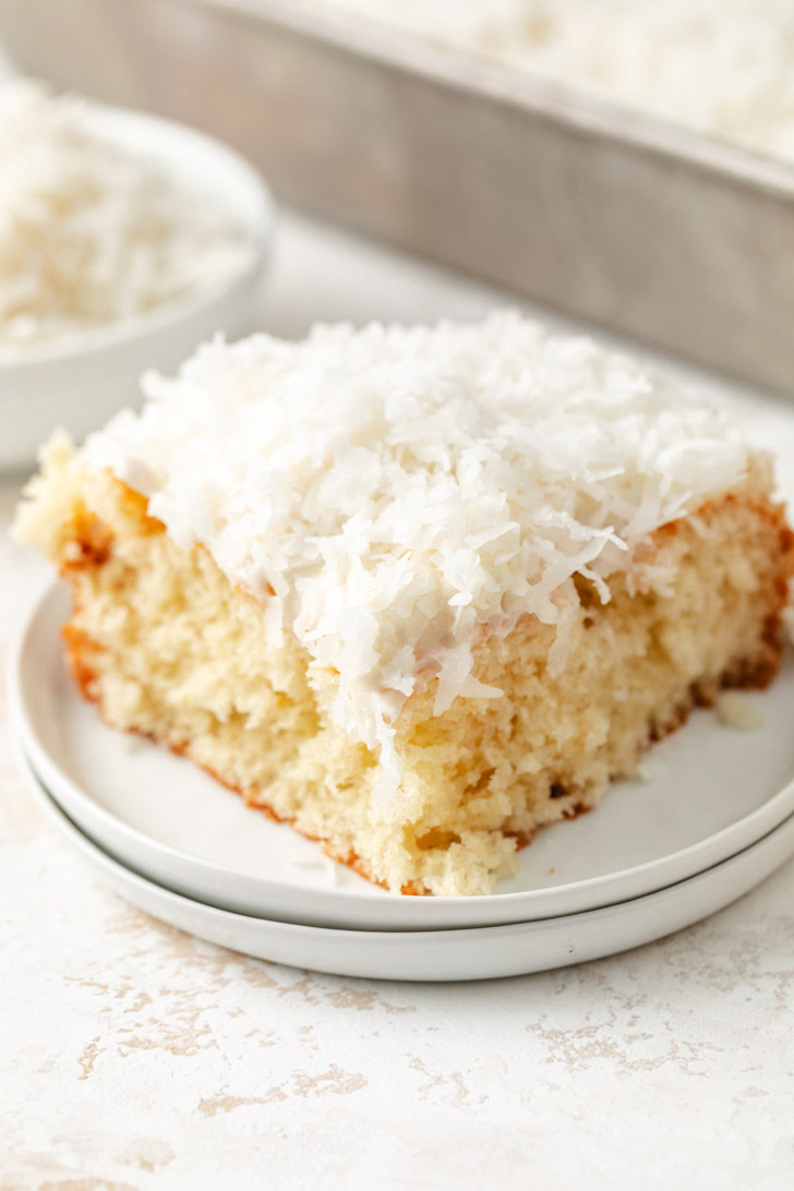 A soft and fluffy coconut cake with cream cheese frosting and coconut topping.