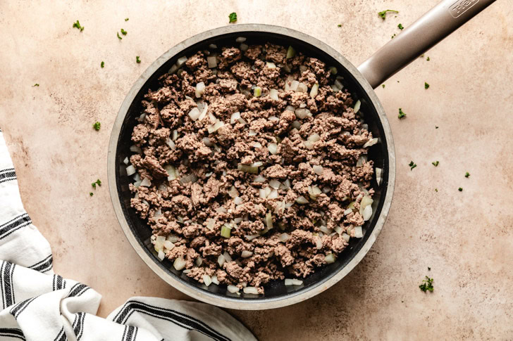 A skillet of ground beef and onions being browned.