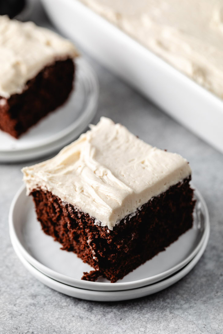 Slice of chocolate cake on a stack of plates.