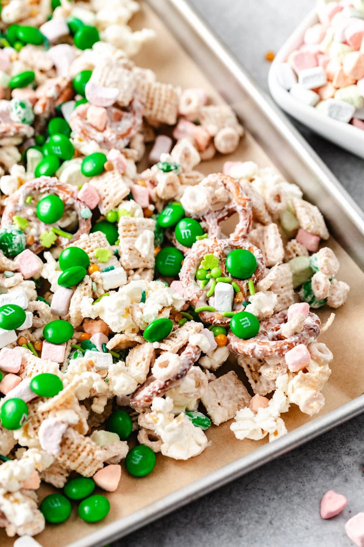 A sweet and salty snack mix with popcorn, pretzels, and green and pastel-colored candies.