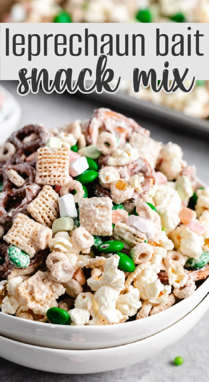 A close-up of a festive leprechaun bait snack mix with cereal, pretzels, popcorn, and m&ms coated in a vanilla candy shell.