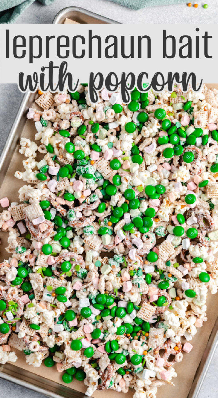 A sheet pan with leprechaun bait spread out, showing green m&ms, cereal, and pretzels coated in vanilla melting wafers.