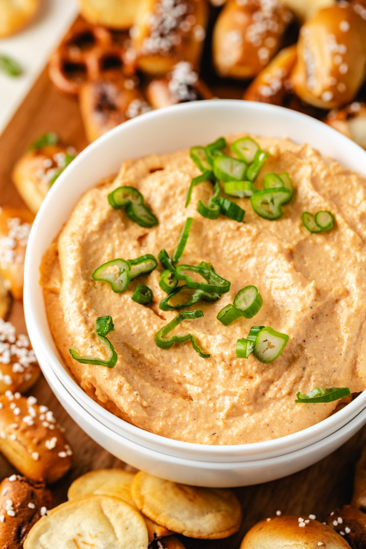 A close-up of a thick and creamy pub cheese spread in a white bowl.